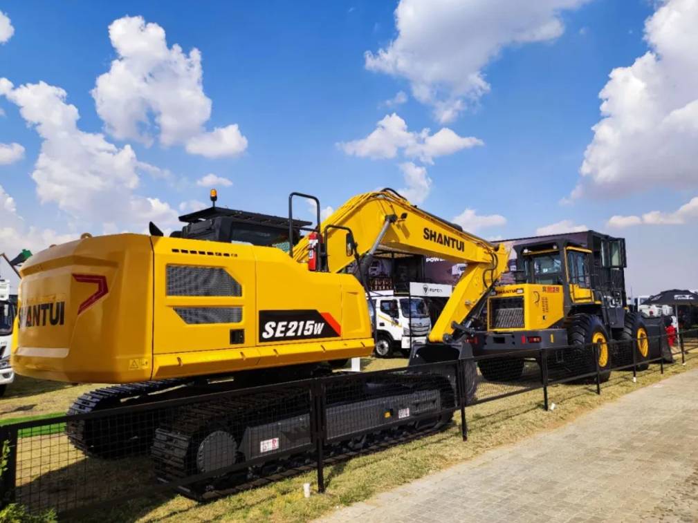Shantui construction machines including excavator and crawler equipment displayed at an international heavy equipment exhibition